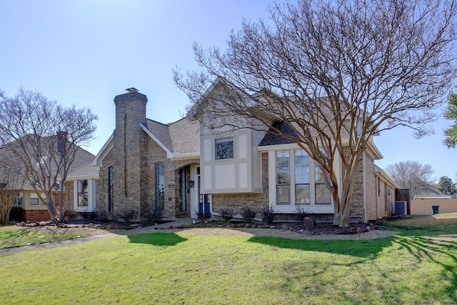 view of front of property with a front yard, central AC unit, brick siding, and a chimney