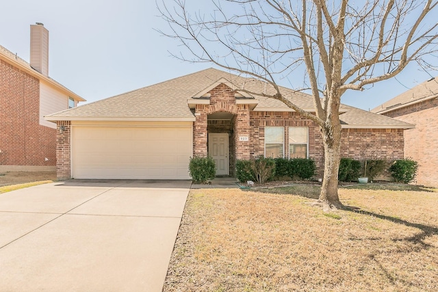 ranch-style home featuring an attached garage, brick siding, driveway, and roof with shingles