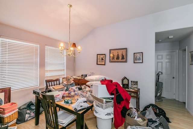 dining room featuring an inviting chandelier, vaulted ceiling, and light wood-style floors