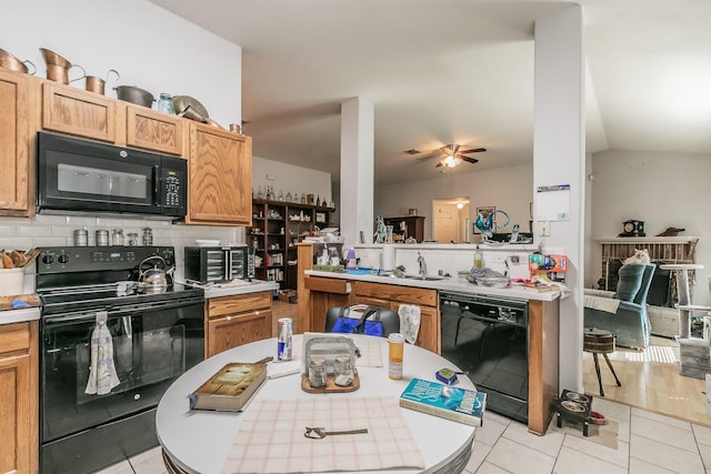 kitchen featuring decorative backsplash, black appliances, light tile patterned floors, and light countertops