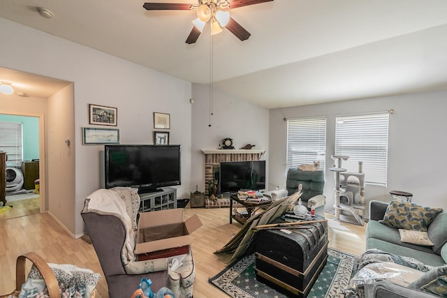 living room featuring a ceiling fan, baseboards, and light wood finished floors