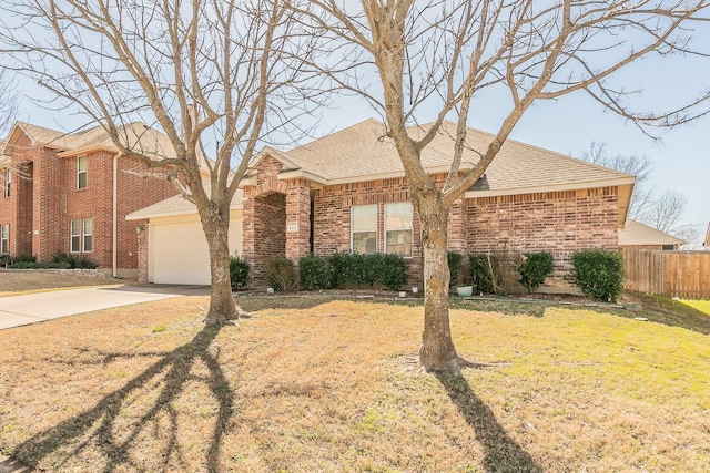 view of front of home with brick siding, an attached garage, driveway, and fence