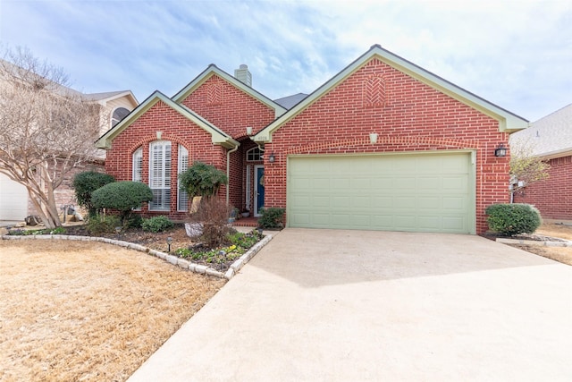 view of front facade with brick siding, driveway, a chimney, and a garage