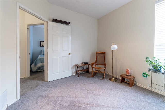 living area with visible vents, baseboards, and carpet flooring