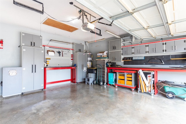 garage with gas water heater, a workshop area, and a garage door opener