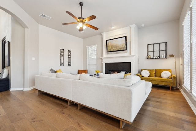 living room with a wealth of natural light, visible vents, wood-type flooring, and a fireplace