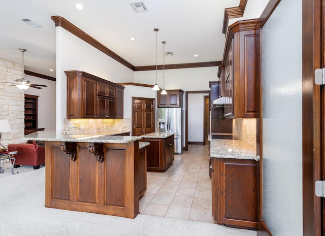 kitchen featuring visible vents, a peninsula, ceiling fan, and stainless steel fridge with ice dispenser