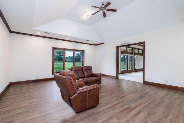 living area with visible vents, lofted ceiling, baseboards, and wood finished floors