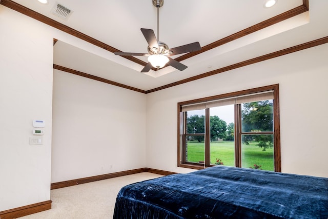 bedroom featuring carpet, baseboards, visible vents, a tray ceiling, and ornamental molding