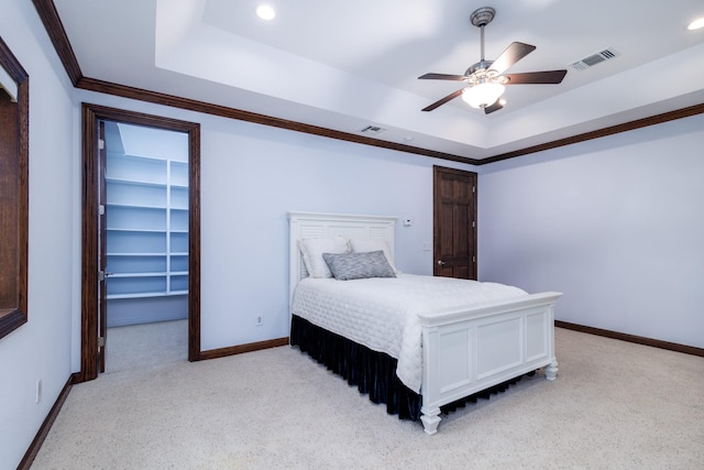 bedroom featuring a spacious closet, visible vents, a raised ceiling, and baseboards