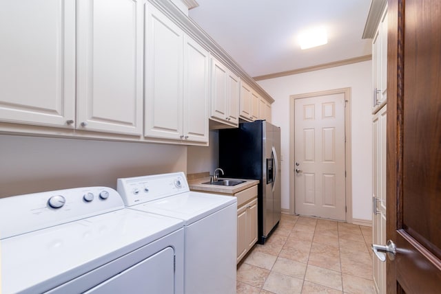 laundry area with a sink, washing machine and dryer, cabinet space, crown molding, and baseboards