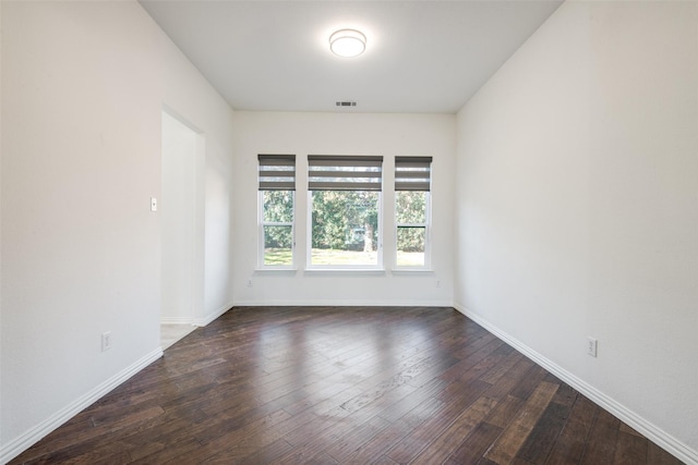 unfurnished room with dark wood finished floors, baseboards, and visible vents