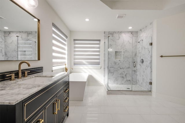 full bath featuring a freestanding tub, visible vents, recessed lighting, a marble finish shower, and vanity