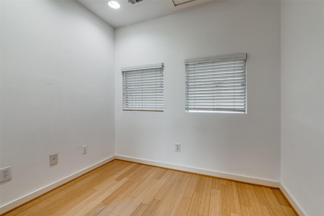 empty room with visible vents, wood finished floors, and baseboards