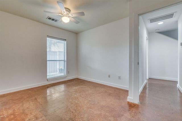 unfurnished room featuring finished concrete flooring, visible vents, and baseboards