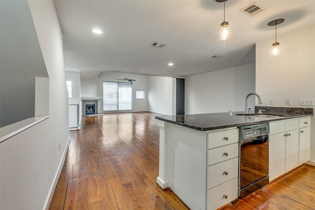 kitchen with visible vents, light wood-style flooring, a sink, a peninsula, and dishwasher