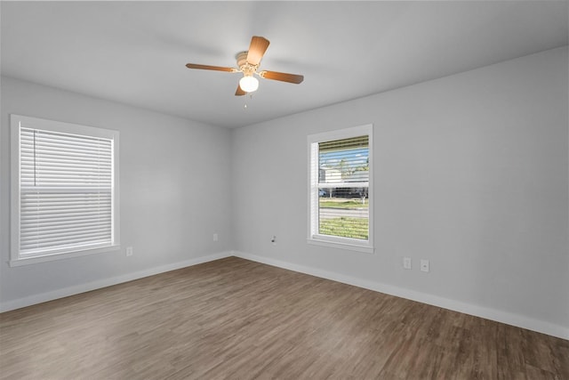 unfurnished room with wood finished floors, baseboards, and ceiling fan