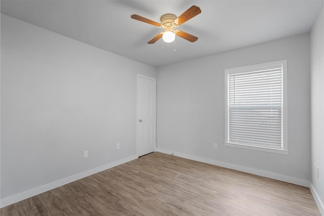 empty room featuring a ceiling fan, baseboards, and wood finished floors