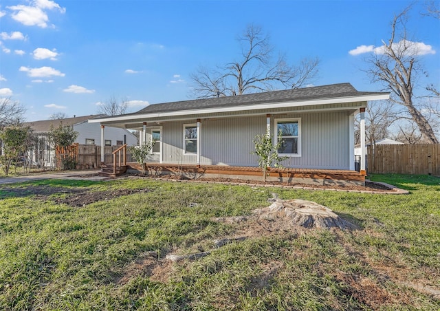 view of front facade with a porch, a front yard, and fence