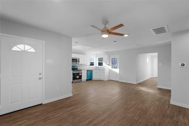 unfurnished living room with visible vents, baseboards, and wood finished floors