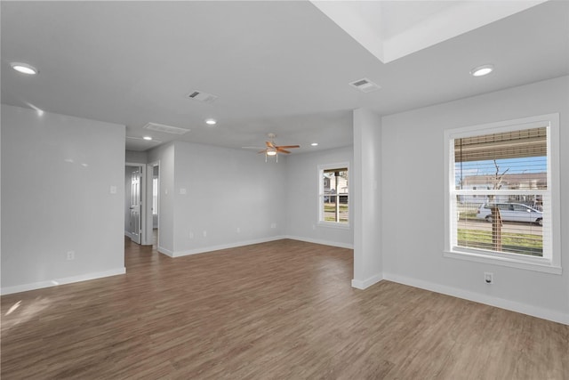 unfurnished room featuring recessed lighting, wood finished floors, visible vents, and baseboards