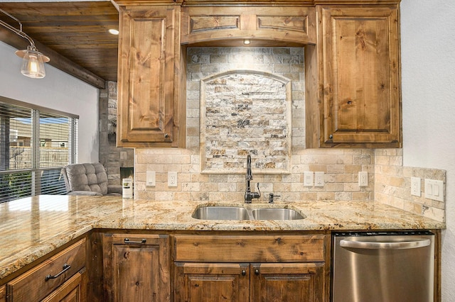 kitchen featuring backsplash, light stone countertops, dishwasher, brown cabinets, and a sink