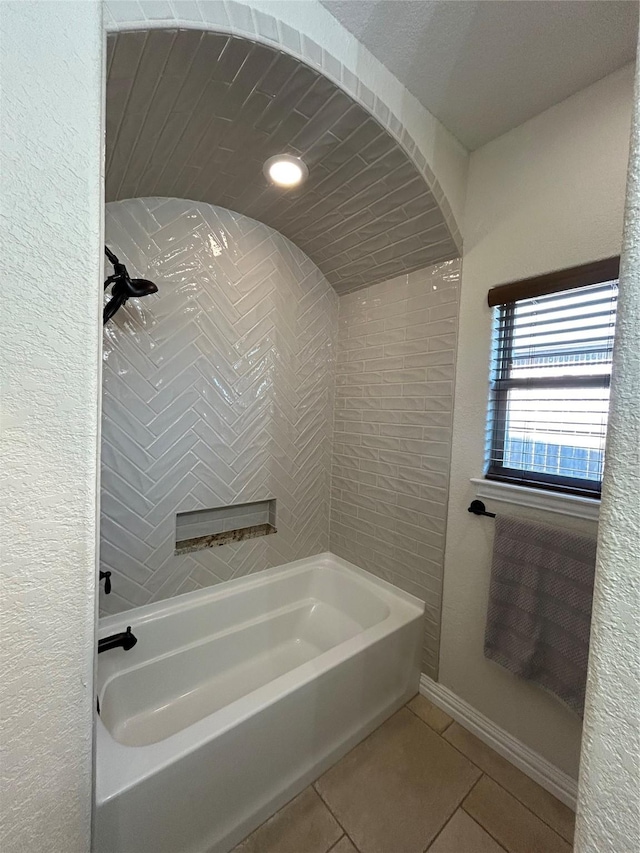 bathroom with tile patterned floors, baseboards, and washtub / shower combination