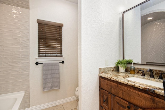 full bathroom with vanity, baseboards, a bathing tub, tile patterned floors, and toilet