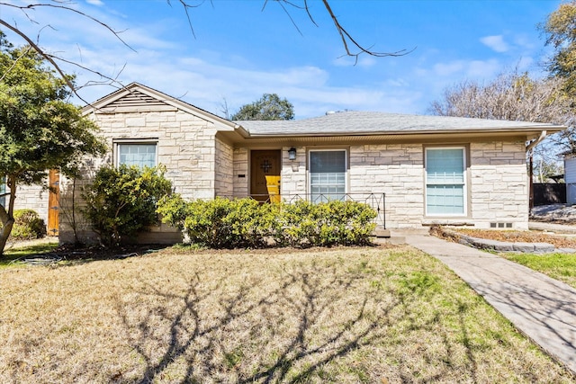 single story home with stone siding, a shingled roof, and a front lawn