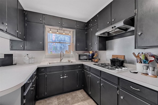 kitchen with white gas cooktop, a sink, light countertops, under cabinet range hood, and stainless steel microwave