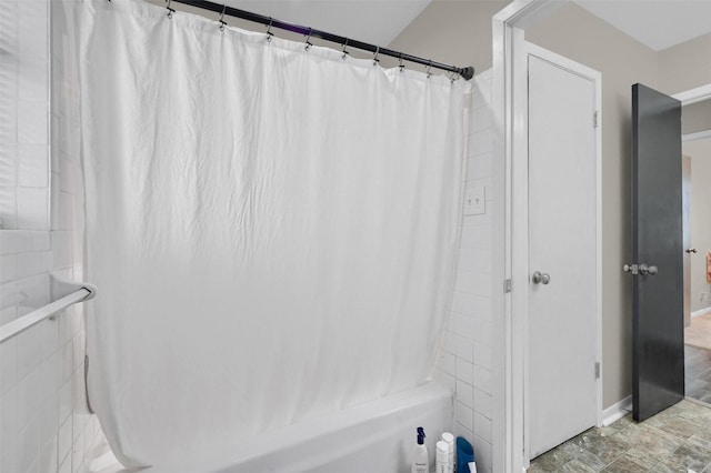 full bath featuring curtained shower and baseboards