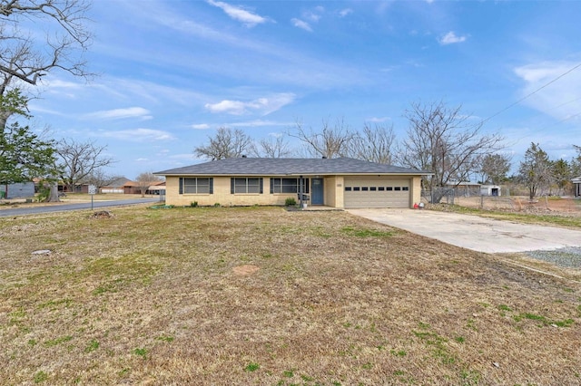 ranch-style house featuring concrete driveway, fence, a garage, and a front yard