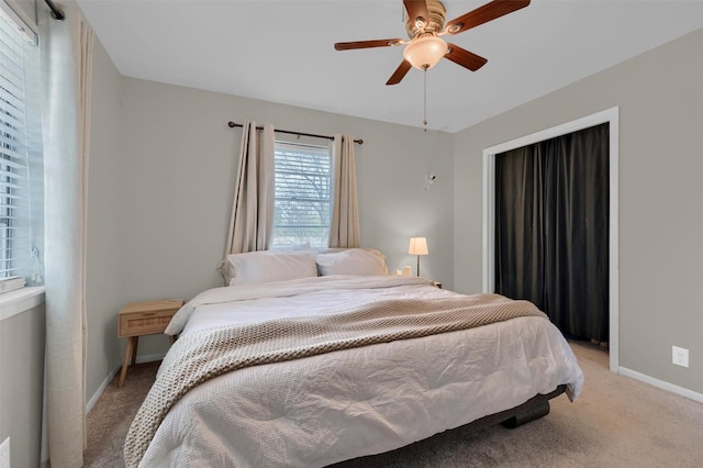 bedroom featuring light colored carpet, baseboards, and ceiling fan