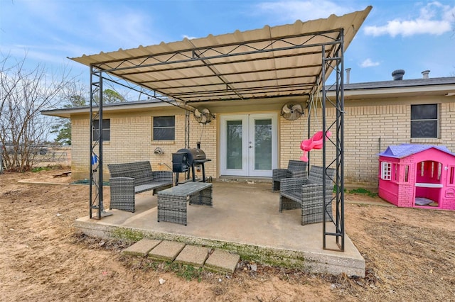 back of house featuring an outdoor living space, french doors, a patio, and brick siding