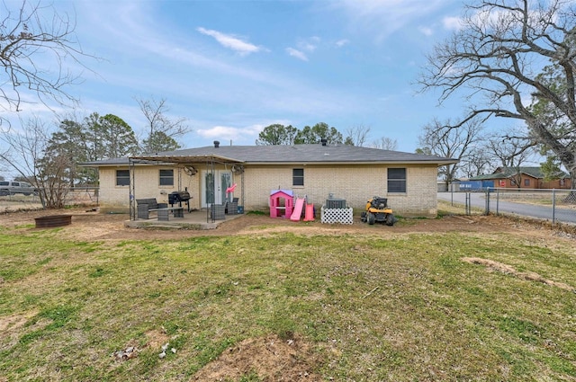 back of property with a patio, central AC, a fenced backyard, a yard, and brick siding