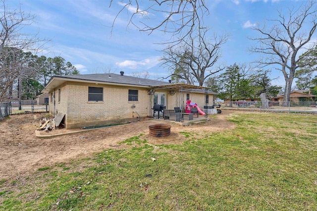 rear view of house featuring a patio, a fenced backyard, a yard, a fire pit, and brick siding