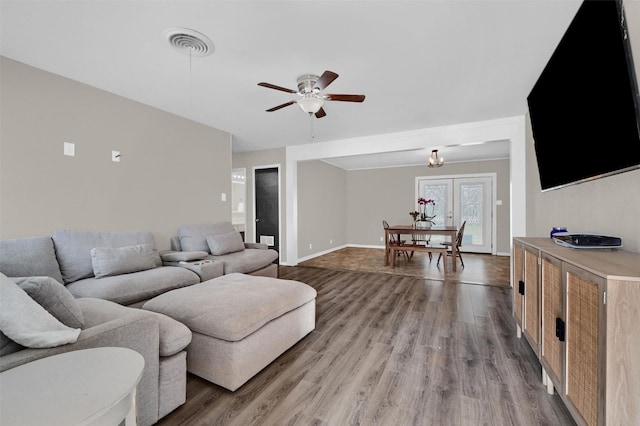 living room with light wood-style flooring, baseboards, visible vents, and ceiling fan