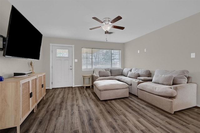 living room with baseboards, dark wood-style floors, and a ceiling fan