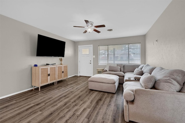 living room featuring visible vents, baseboards, a ceiling fan, and wood finished floors