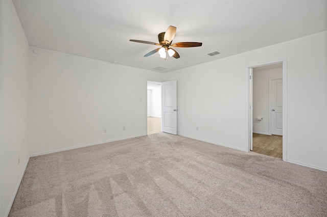 empty room featuring visible vents, carpet flooring, baseboards, and a ceiling fan