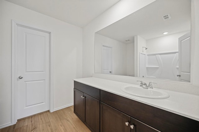 bathroom with visible vents, walk in shower, wood finished floors, and vanity