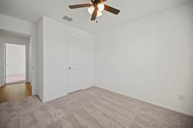 unfurnished bedroom with a ceiling fan, baseboards, visible vents, and light carpet