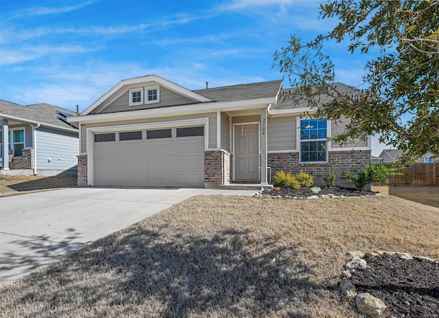 view of front of home featuring brick siding, an attached garage, driveway, and fence