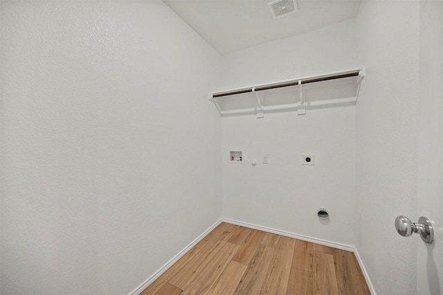 laundry room featuring visible vents, laundry area, light wood-style flooring, electric dryer hookup, and hookup for a gas dryer