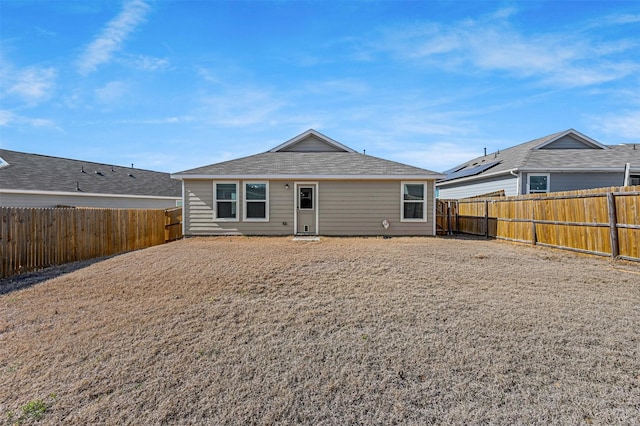 rear view of house featuring a fenced backyard