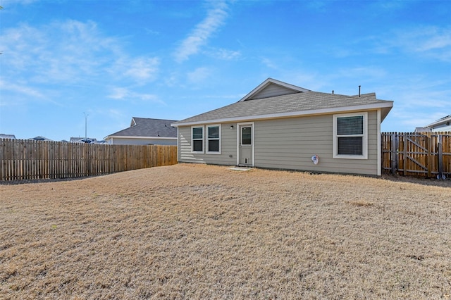 back of house with a fenced backyard