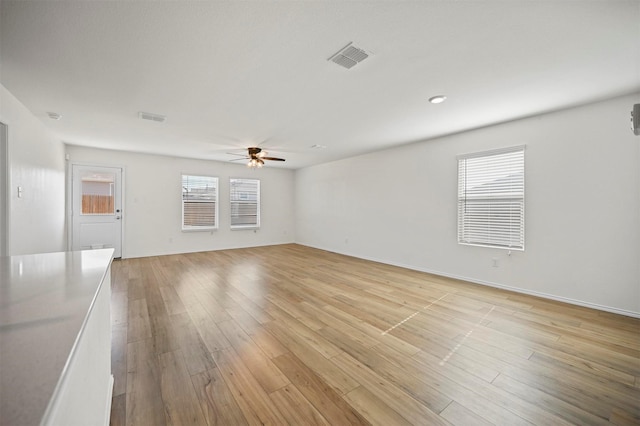 unfurnished living room with light wood-style flooring, visible vents, and ceiling fan