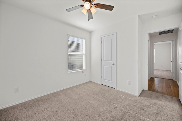 unfurnished bedroom with visible vents, light carpet, baseboards, and ceiling fan