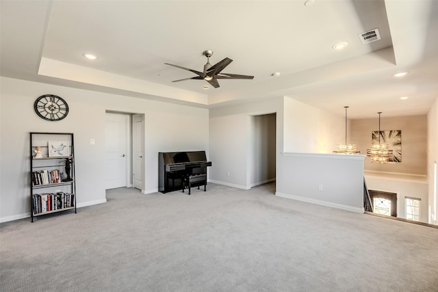 living area featuring recessed lighting, a tray ceiling, light colored carpet, and visible vents