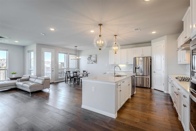 kitchen with a healthy amount of sunlight, visible vents, a sink, appliances with stainless steel finishes, and a chandelier